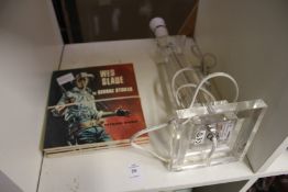A perspex lamp and some books.