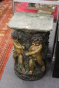 A good large decorative cast bronze stand moulded with Bacchanalian cherubs, with a marble top.