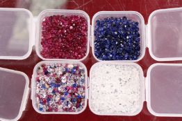 Four small boxes of colourful stones.