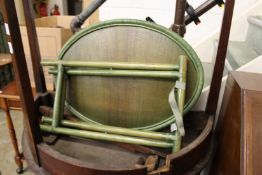 A green stained oval wicker tray with folding stand.