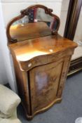 A Victorian inlaid walnut serpentine fronted pedestal cabinet with mirrored back.