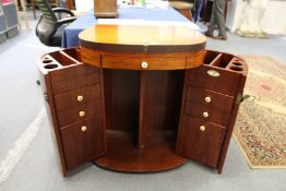 An unusual cabinet with rising top and bi-fold doors including numerous drawers.