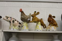 Four unusual pottery groups of a pig, a chicken and two hares.
