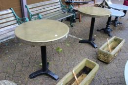A pair of circular brass topped tables.