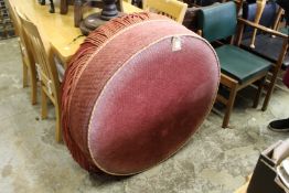 A large circular upholstered stool.
