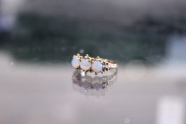 A 9ct gold ring set with three opals.