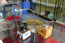 Two coffee grinders and a desk magnifier.