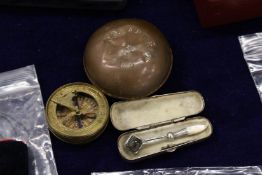 An unusual magnifying device, a brass cased pocket compass and a copper circular box dated 1900.