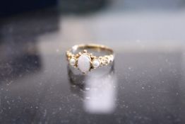 A 9ct gold ring set with an opal and two pearls.
