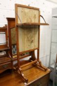 A satinwood fire screen with folding shelf.