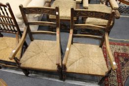 A pair of rush seated oak ladder back armchairs.