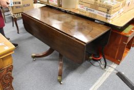 A mahogany drop flap pedestal dining table.