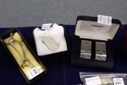 A pair of novelty silver pheasant shaped knife rests, a silver money clip and two plated napkin