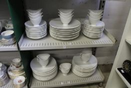 A quantity of plain white dinner plates and serving bowls.