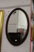 A mahogany oval mirror.