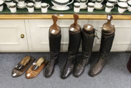 Two pairs of riding boots with wooden trees and two hunting trophies.