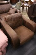 A modern brown leather upholstered armchair.