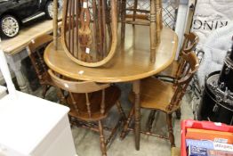 A kitchen table and six spindle back chairs.