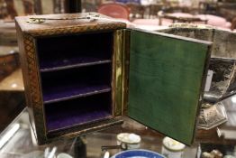 A diced leather jewellery casket with carrying handle and hinged door.