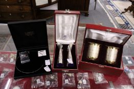 A boxed pair of vases, a pair of gilt metal cups and a necklace.