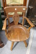 An Edwardian oak swivel armchair.