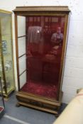 A good large walnut cased display cabinet with carved cornice, similar base with carved paw feet.