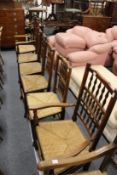 Six 19th century ash and elm rush seated spindle back dining chairs, two with arms.