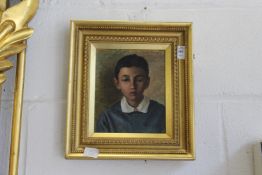A portrait bust of a young boy wearing a blue jumper, oil on board.