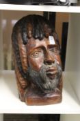 A carved wood bust of a bearded man.
