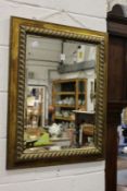 A decorative gilt framed wall mirror.