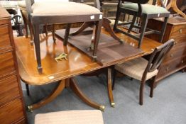 A George III design mahogany twin pillar dining table with one extra leaf.