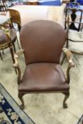 A Georgian style armchair on carved cabriole legs.