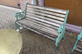 A garden bench with green [painted cast metal ends.