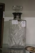 A cut glass whisky decanter with silver collar.