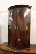 A George III mahogany bow front hanging corner cabinet.