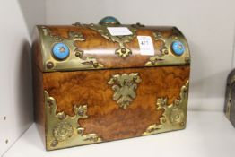 A Victorian walnut stationery casket with brass mounts and cabochon stones.