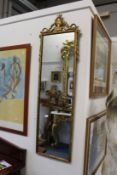 A gilt framed dressing mirror with urn finial.
