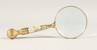 A MAGNIFYING GLASS with a gilt and mother of pearl handle.