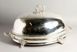 A LARGE PLATED OVAL MEAT DISH AND COVER with gadrooned edge, carrying handles and four curving