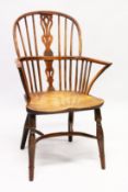 AN 18TH CENTURY YEW WOOD WINDSOR ARMCHAIR with crinoline stretcher.