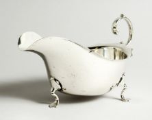 A GEORGE V SILVER SAUCE BOAT on three pad feet. Chester 1907. 19cm long - 219g
