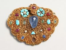 AN INDIAN PENDANT set with a carbouchon sapphire and other stones 3.5ins x 3.75ins.