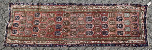 A GOOD PERSIAN RUNNER, rust ground with all over Botch decoration. 9ft 2ins x 2ft 10ins.