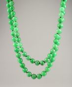 A VERY GOOD SET OF JADE BEADS with a 18ct gold clasp 44ins long.