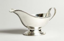 A GEORGE V SILVER SAUCE BOAT with reeded edge and handle. London 1934. 19cm long - 197g