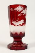 A BOHEMIAN RUBY TINTED GOBLET etched with deer. 7ins high.