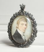 A GEORGIAN OVAL MINIATURE OF A YOUNG MAN, in a silver frame. 2.5ins x 2ins.