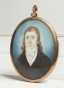 AN GEORGIAN OVAL MINIATURE OF A YOUNG MAN, the reverse with plated hair. 2.5ins x 2ins.