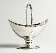 A GEORGE III SILVER BOAT SHAPED SUGAR BASKET with reeded swing handle, crested. London 1788, maker