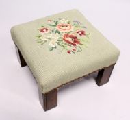 A SQUARE STOOL with needlework top. 11ins high